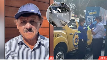 Un hombre mayor con gorra azul, un automóvil con pintura blanca en el parabrisas y un paramédico atendiendo a una persona en la calle