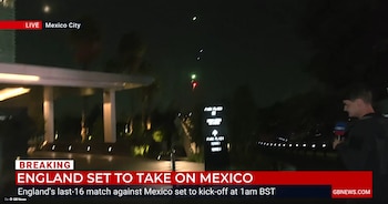Vista nocturna de un hombre con micrófono de GB News frente a un edificio con cartel "Park Plaza", con luces de colores en el cielo. En pantalla, texto "LIVE Mexico City"