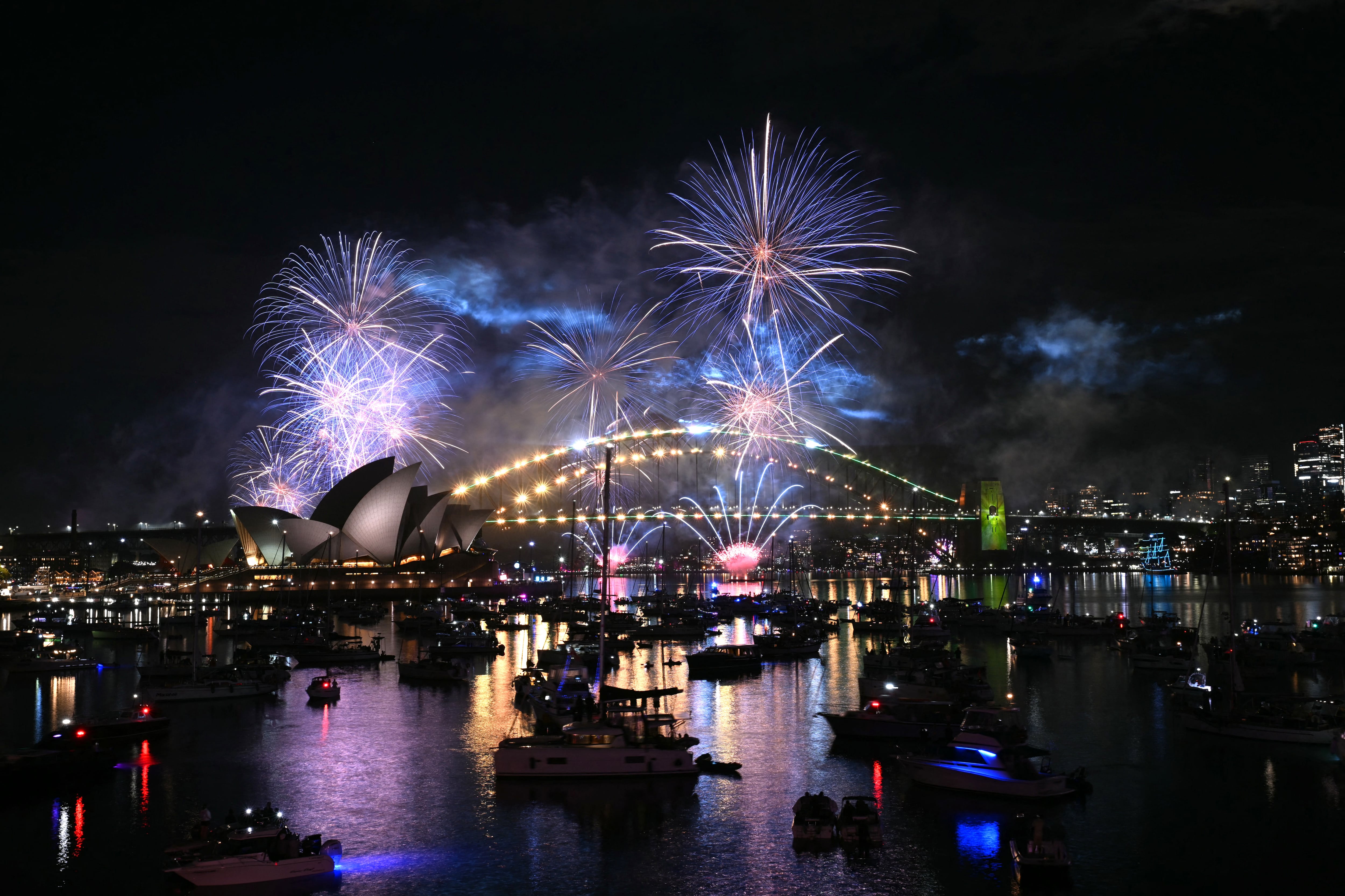 Fuegos artificiales de medianoche sobre el puerto de Sídney, en celebraciones marcadas por un minuto de silencio por las víctimas de Bondi Beach. Sídney, 1 de enero de 2026. (Foto: Saeed KHAN / AFP)