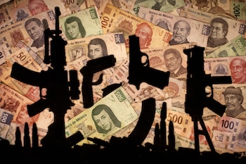 Siluetas de rifles, pistolas, cargadores y balas sobre una superficie cubierta con billetes de pesos mexicanos de 50, 100, 200 y 500.