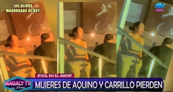 Pedro Aquino y su esposa son vistos de espaldas bailando en un ambiente interior con iluminación tenue. Él viste de oscuro, ella de claro
