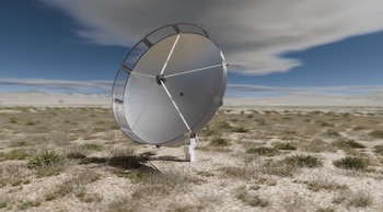 Un radiotelescopio plateado con estructura circular en un terreno árido con arbustos secos y cielo azul con nubes
