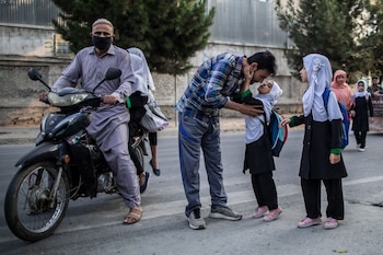 Una niña afgana besa a su padre antes de ingresar a su escuela primaria en Kabul. Foto: Oliver Weiken/dpa