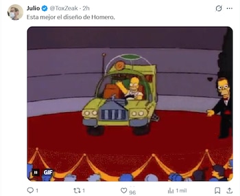 Homero Simpson conduciendo su extravagante auto amarillo con burbuja, en una alfombra roja, siendo presentado por un hombre de traje