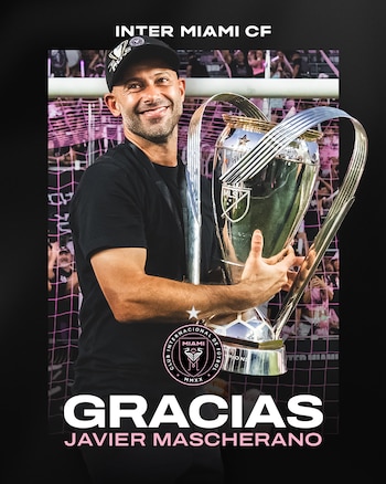 Javier Mascherano, sonriendo y vistiendo camiseta negra y gorra, sostiene un trofeo de fútbol plateado con el logo de la MLS, con una portería de fondo