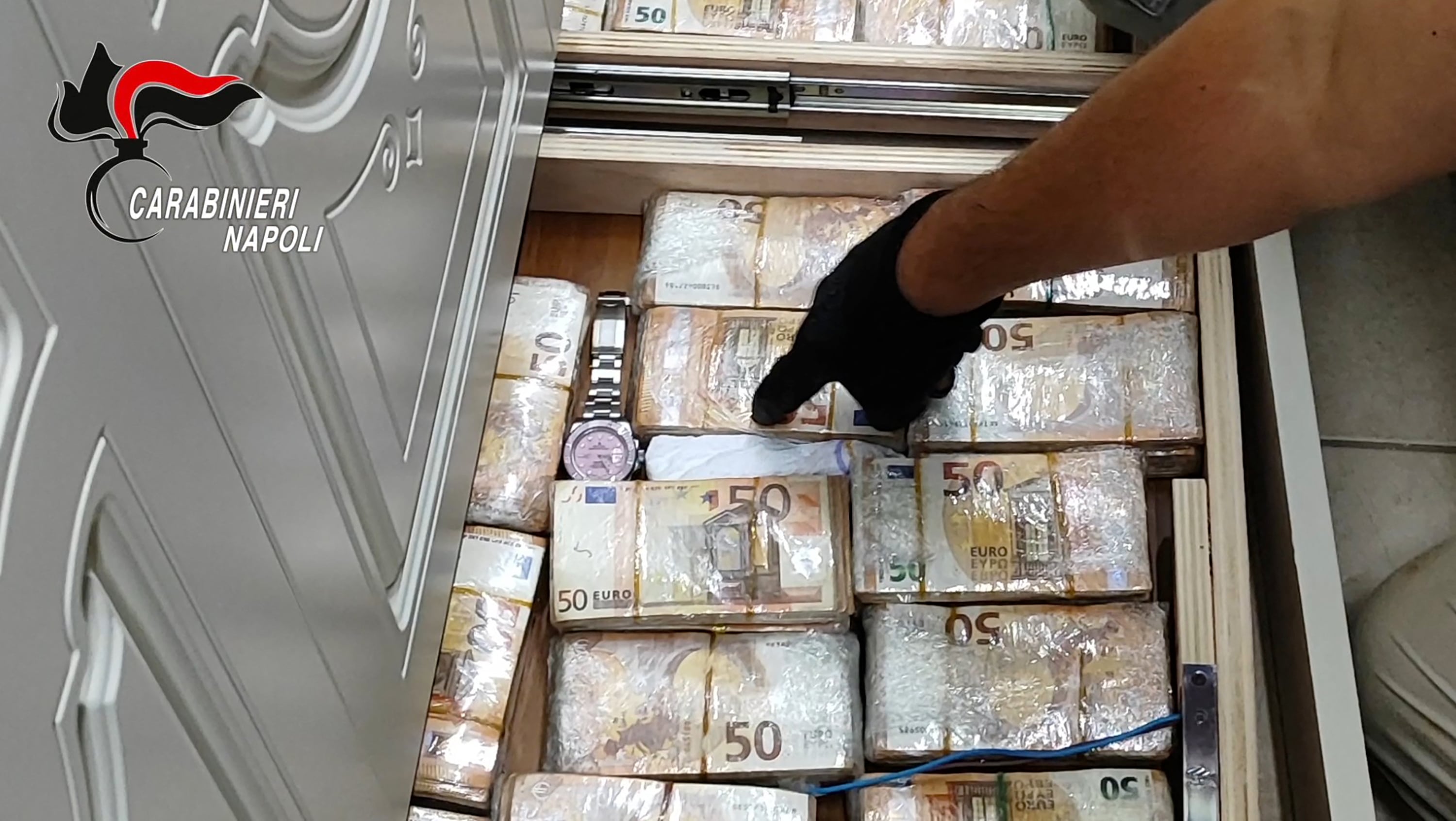 Billetes ocultos en una pared, hallados por los Carabineros italianos durante un allanamiento en Caivano, cerca de Nápoles, el 22 de septiembre de 2026 (Carabineros italianos/vía AFP)