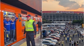 Un vagón naranja de metro con aficionados y un policía en el andén, junto al estacionamiento con vehículos frente al Estadio Banorte.