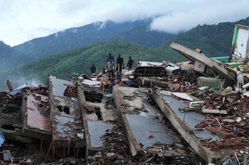 Los residentes buscan entre los escombros de un edificio que se derrumbó durante los terremotos en La Guaira, Venezuela, el martes 30 de junio de 2026. (AP Foto/Ariana Cubillos)