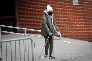 Una anciana con una mascarilla espera a ser atendida en Nueva York (Reuters)