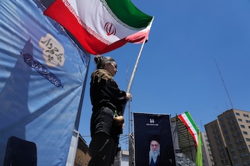 Una mujer ondea una bandera iraní durante una marcha en el centro de Teherán, Irán (AP Foto/Vahid Salemi)