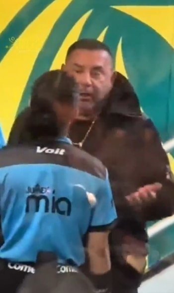 Antonio Mohamed viste una chaqueta oscura frente a la árbitra Katia Itzel García, quien luce una camiseta azul con logotipos