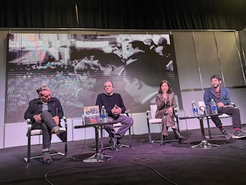 Fernando "Rapa", Ernesto Tenembaum, María O'Donnell y Hernán Confino sentados en un escenario con una pantalla digital de fondo que proyecta una imagen en B/N