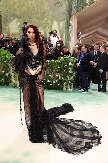 Dua Lipa acaparando las miradas en la Met Gala 2024 luciendo un audaz diseño gótico en encaje negro y plumas (REUTERS/Andrew Kelly)