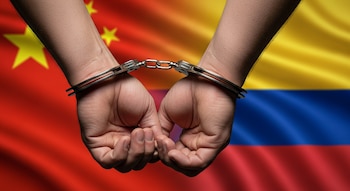 Primer plano de dos manos masculinas esposadas con puños apretados, superpuestas a las banderas ondeantes de China y Colombia.