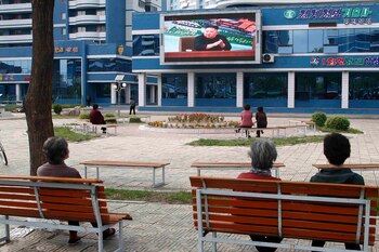 Unas personas ven noticias relacionadas