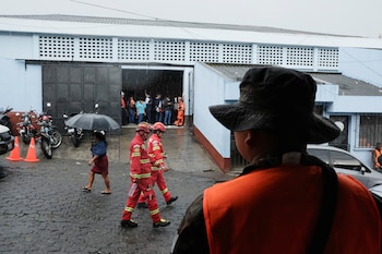 Personal de emergencia trabaja en las afueras de un albergue municipal donde se han refugiado residentes de comunidades cercanas al Volcán de Fuego tras ser evacuados por las autoridades locales, en San Juan Alotenango, Guatemala, el 5 de junio de 2025. REUTERS/Josue Decavele