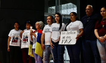 Ocho personas protestan. Visten camisetas por presos políticos y algunos portan una vela, bandera venezolana y un cartel que dice 'Sin Justicia No Hay Paz'