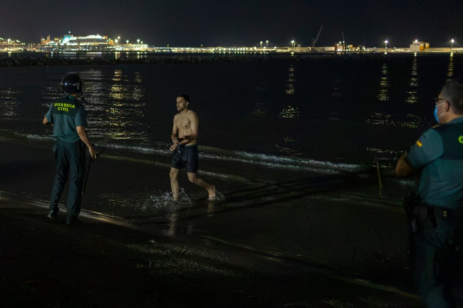 Un miembro de la Guardia Civil espera la llegada de un migrante que ha cruzado de forma irregular en la noche de este jueves la frontera marroquí con Melilla. EFE / Giner.