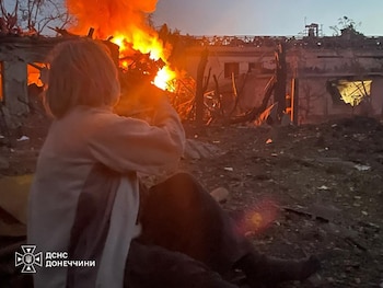 Una mujer observa un edificio residencial dañado por un ataque aéreo ruso en Sloviansk, región de Donetsk (Ukrainian Emergency Service via AP)