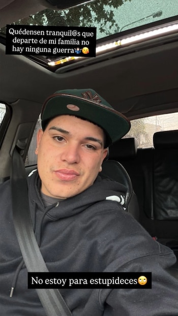 Thiago Medina, un joven con gorra verde y sudadera negra, sentado en el asiento del conductor de un coche, mirando directamente a la cámara. Lleva puesto el cinturón de seguridad