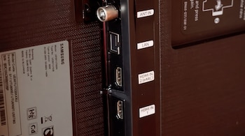 Panel trasero de un televisor Samsung con puertos ANT IN, LAN, HDMI IN 1 y HDMI IN 2 (eARC), etiqueta de modelo UE50TU7020KXXU, y código de barras.