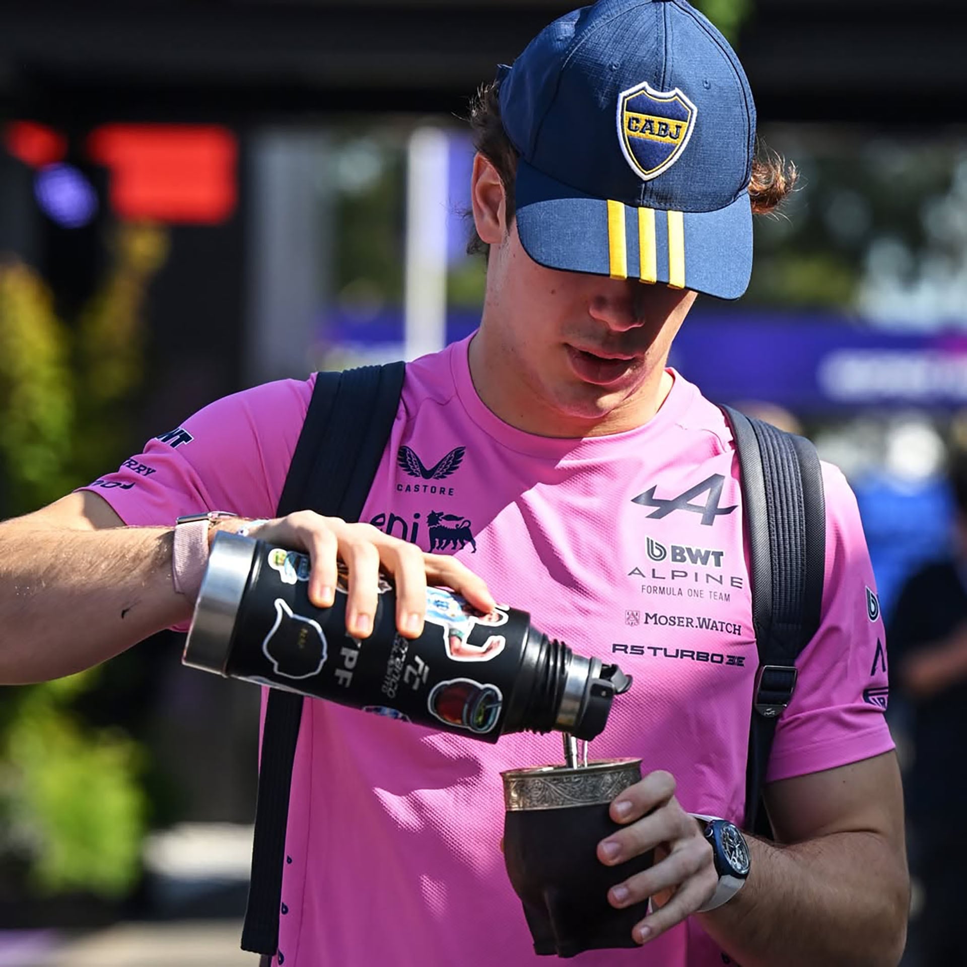 Colapinto, con una gorra de Boca Juniors, se prepara un mate en el paddock