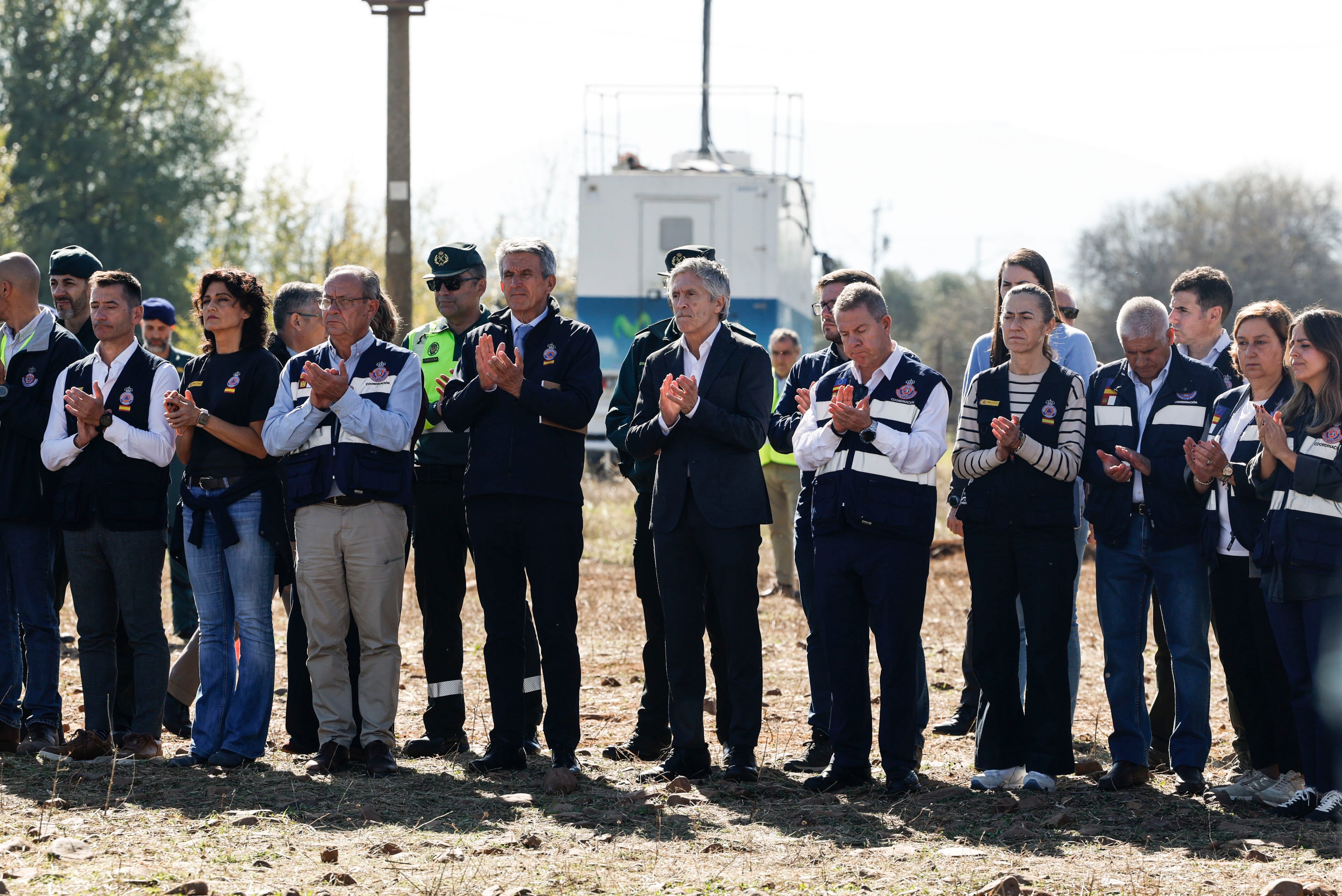 El ministro del Interior, Fernando Grande-Marlaska y el presidente de Castilla-La Mancha, Emiliano García-Page, aplauden tras guardar este jueves un minuto de silencio en el puesto de mando avanzado (PMA) desplegado en Urda (Toledo). (J.J. Guillén/EFE)