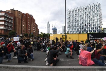 Protesters kneel as they gather in front of the US embassy during the Black Lives Matter protest rally in London, Sunday, June 7, 2020, in response to the recent killing of George Floyd by police officers in Minneapolis, USA, that has led to protests in many countries and across the US. (AP Photo/Alberto Pezzali)