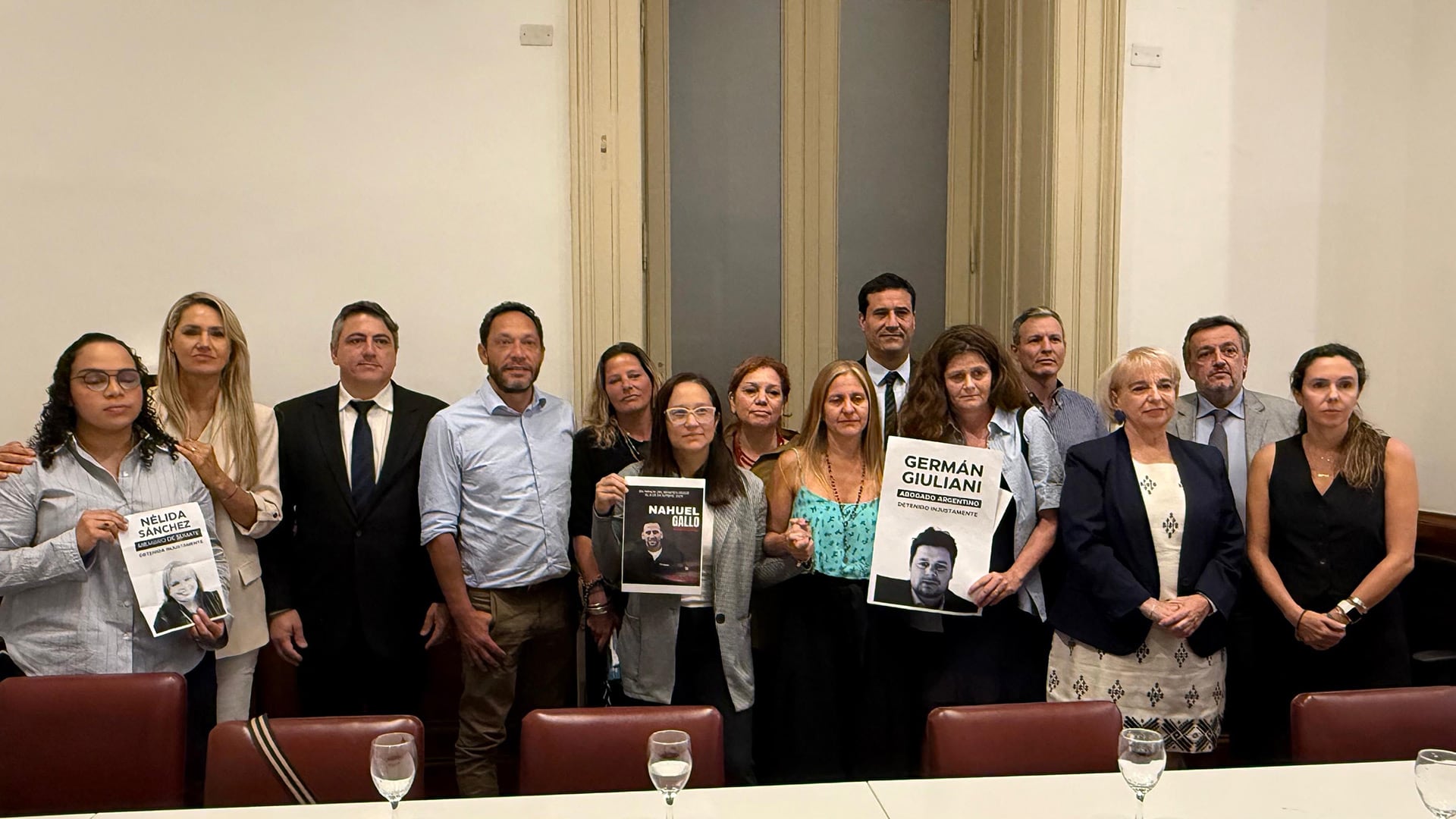 Un grupo de familiares de ciudadanos argentinos detenidos en Venezuela exige la liberación de sus seres queridos mostrando sus retratos