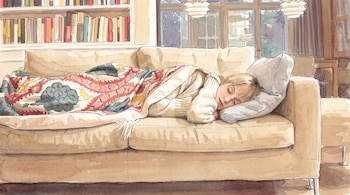 Persona dormida en un sofá beige con una manta estampada y una almohada gris, junto a una estantería con libros y una ventana.
