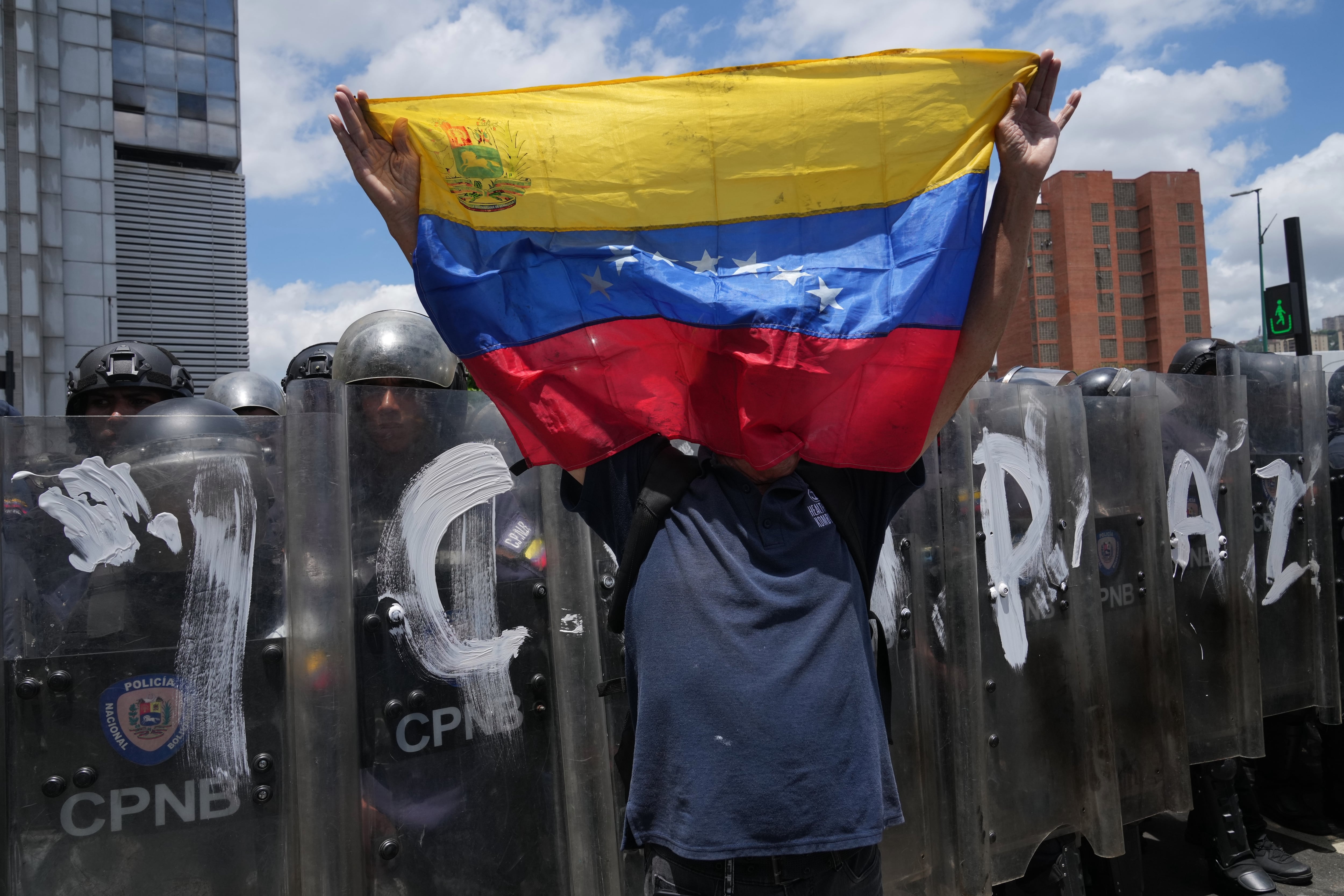 Un hombre ondea una bandera de Venezuela durante una protesta para exigir justicia para Carmen Navas, un día después de su muerte, el lunes 18 de mayo de 2026, en Caracas. (AP Foto/Ariana Cubillos)