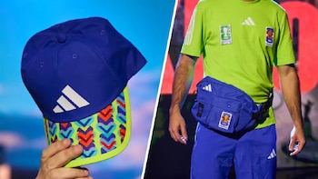 Una gorra azul con logo Adidas y un hombre con camiseta verde, pantalón azul y riñonera azul con el emblema de la Copa Mundial de la FIFA 2026™