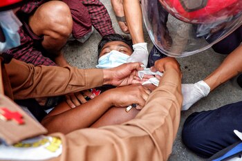 Un hombre herido yace en el suelo después de que la policía disparara balas de goma durante las protestas contra el golpe militar, en Mandalay, Myanmar, el 20 de febrero de 2021. REUTERS / Stringer