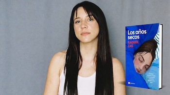 Una mujer de cabello oscuro con camiseta blanca junto a la portada del libro azul Los años secos de Raquel Zas.