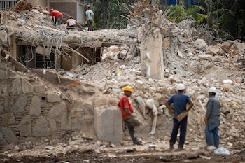 Fotografía del jueves 9 de julio de 2026 que muestra a personas que retiran escombros de un edificio afectado por el doble terremoto en Caracas (Venezuela). EFE/ Ronald Peña R