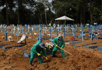 Sepultureros con trajes de protección