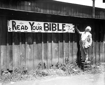 Un ciudadano protesta contra la enseñanza de las ciencias y coloca un cartel con el mensaje "Lea su Biblia" en un muro de Dayton durante los días del "Juicio del Mono"