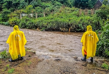 Personal de emergencia supervisa el caudal de un río crecido tras las intensas lluvias provocadas por la depresión tropical Cristina en El Salvador (Cortesía Protección Civil).