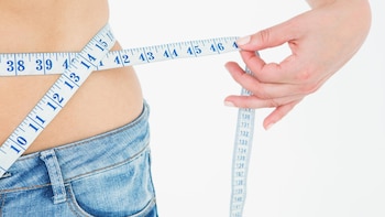 Una mujer midiendo su cintura. (Getty)