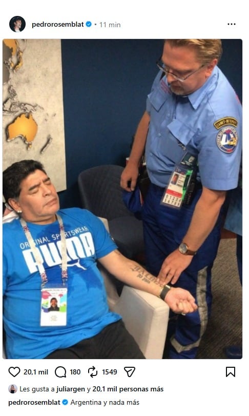 El exfutbolista Diego Maradona se encuentra sentado con los ojos cerrados mientras un paramédico lo asiste en un evento en San Petersburgo.