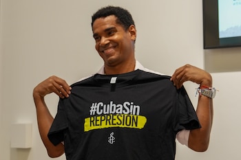 MIAMI (ESTADOS UNIDOS), 25/08/2026.- El artista cubano Luis Manuel Otero Alcántara posa con una camiseta en el acto 'Cartas de libertad y solidaridad' este martes, un evento de Amnistía Internacional (AI), en el que recibió más de 27.000 cartas y mensajes de apoyo que le enviaron personas de todo el mundo durante sus cinco años preso en Cuba y que, contó, nunca llegó a leer, en Miami (EE.UU.). EFE/ Alberto Boal