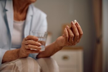 Una mujer toma un suplemento (AdobeStock)