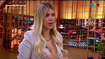 Wanda Nara, vestida con una chaqueta blanca y un collar dorado, habla en un estudio de televisión