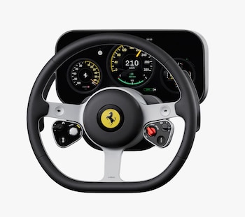 Primer plano de un volante de Ferrari negro y plateado con el logo del caballo rampante, frente a una pantalla digital con velocímetro a 210 km/h