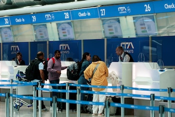Pasajeros hacen el check-in para