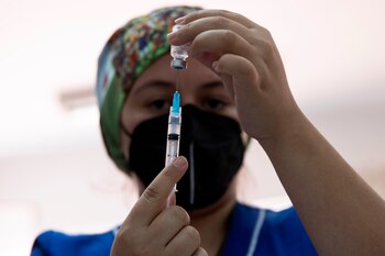 Una enfermera prepara una dosis