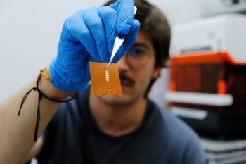 El investigador Yigit Sozen sostiene un chip en un trozo de piel. (Ángela R. Bonachera / ICMM-CSIC)