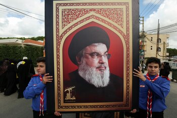 Jóvenes sostienen un cuadro de Hassan Nasrallah (REUTERS/Aziz Taher)