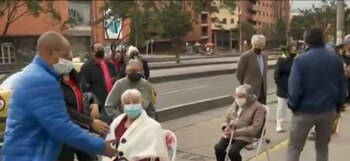 Adultos mayores esperan en sillas