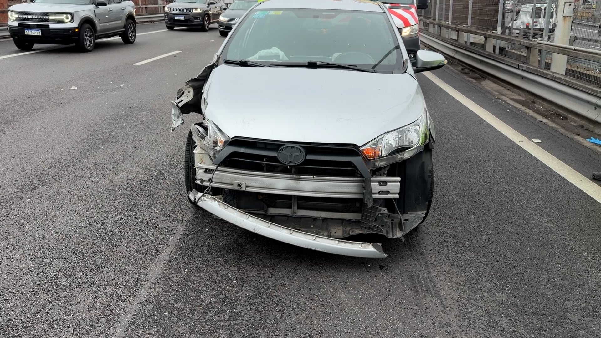 Un automóvil gris con daños frontales permanece en una carretera de Retiro tras un choque múltiple.